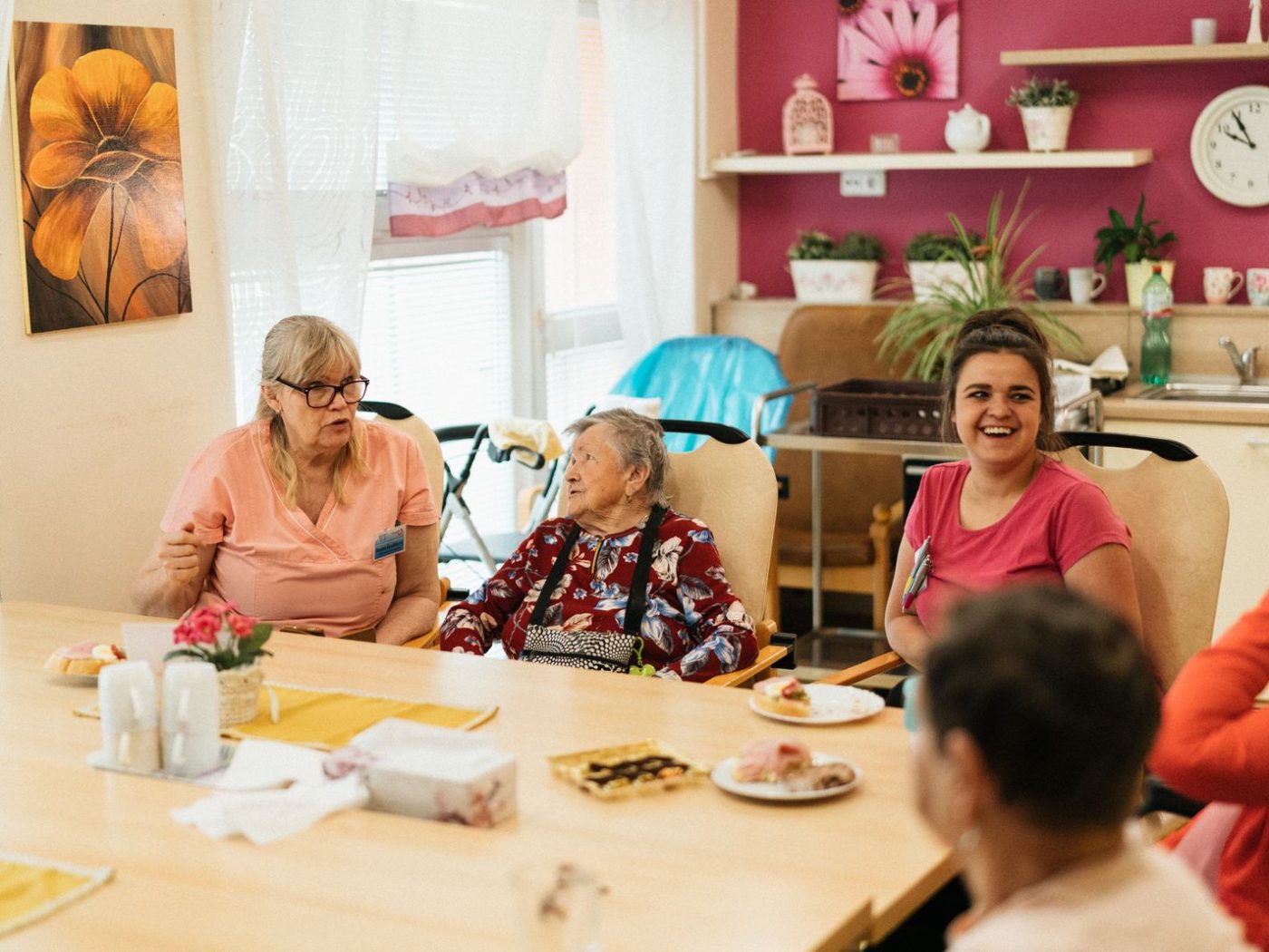 Seniorinnen und Senioren verbringen gemeinsam Zeit am Tisch mit Betreuung