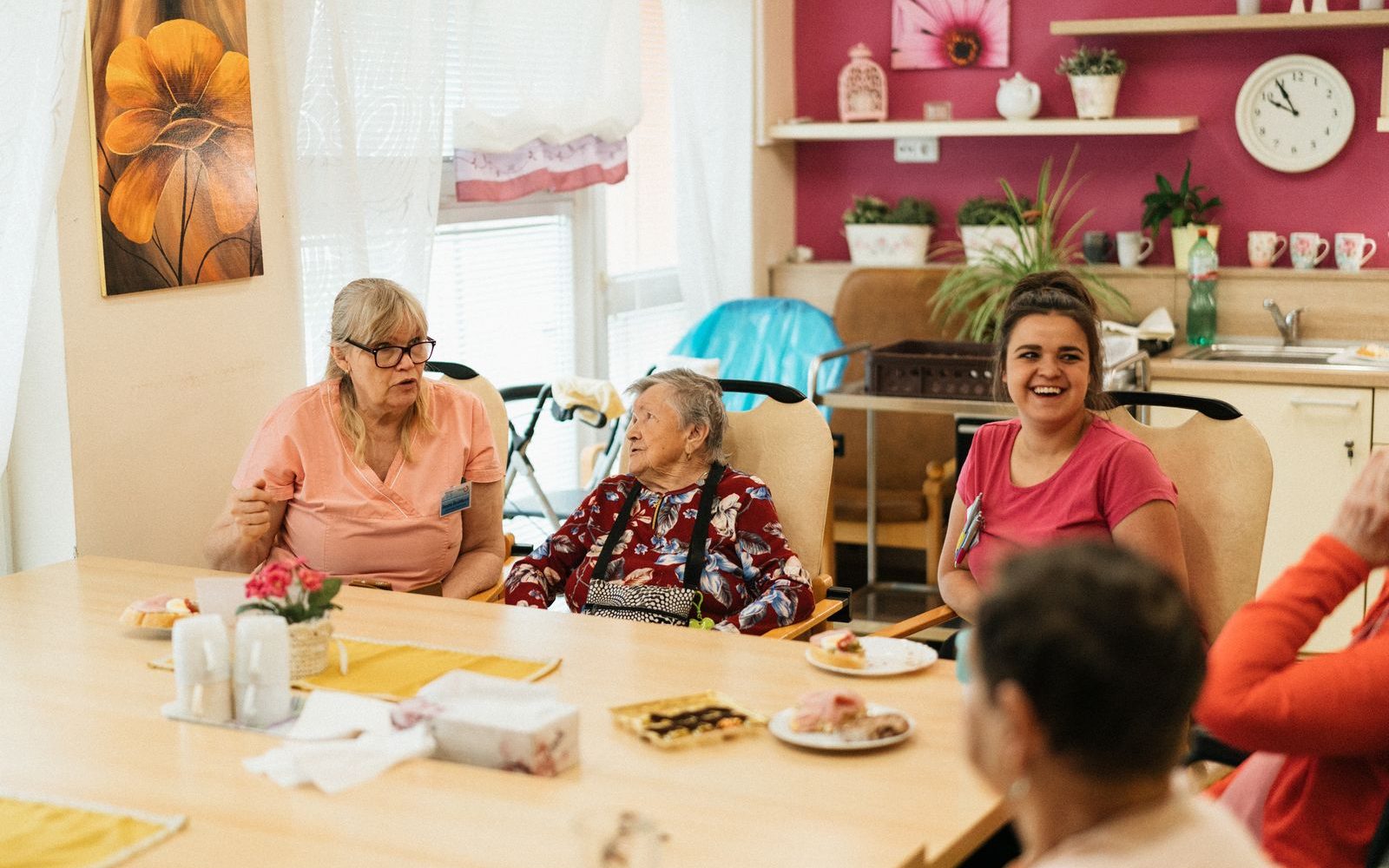 Seniorinnen und Senioren verbringen gemeinsam Zeit am Tisch mit Betreuung